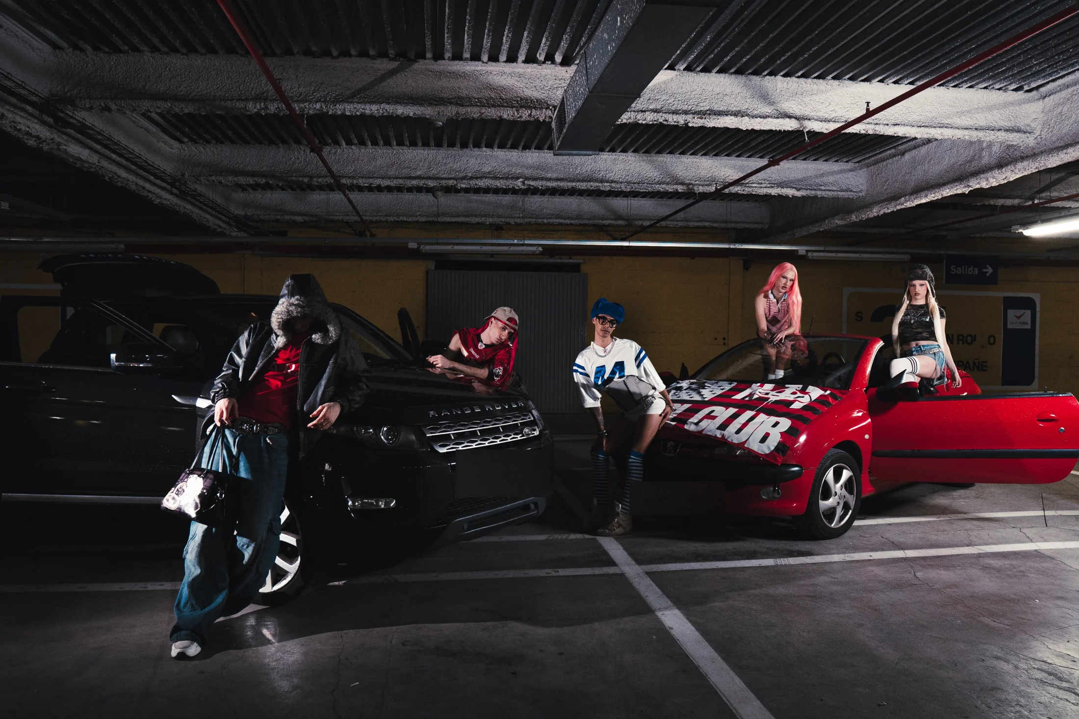 Artistas de Underground Sound en un garaje de Valencia, junto a un coche rojo